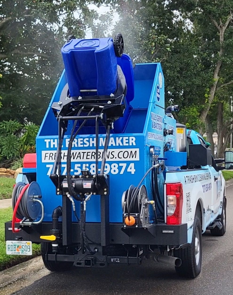 A garbage truck is parked on the side of the road