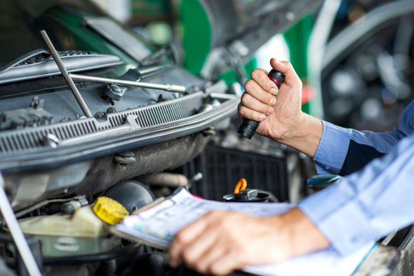 Un uomo stringe la mano a un altro uomo mentre tiene in mano le chiavi di un'auto.