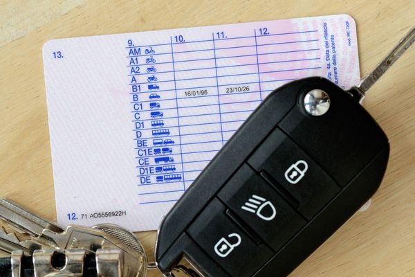 Un primo piano della chiave di un'auto accanto a una patente di guida