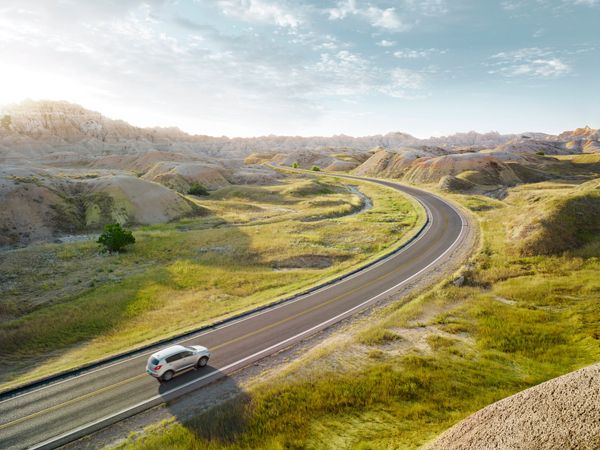 Un'auto percorre una strada tortuosa nel deserto.