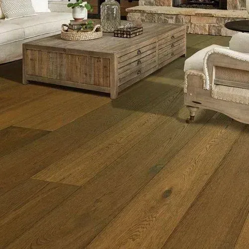 Hardwood flooring in a living room setting with a wooden coffee table and a beige couch and armchair.