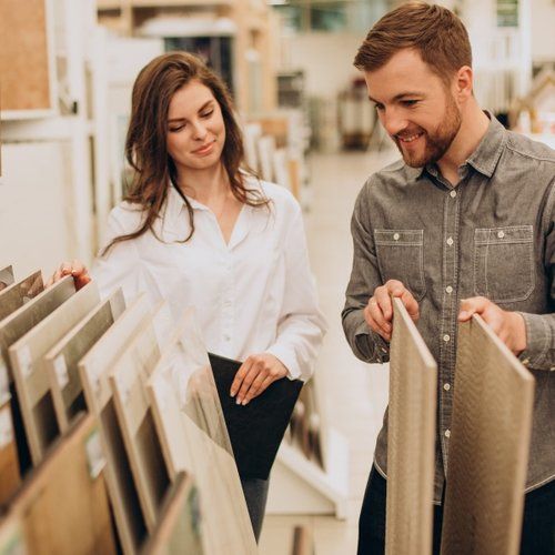 A man and a woman are looking at tiles in a store.