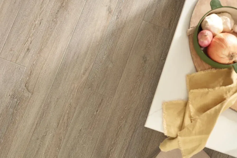 Light brown textured flooring with a white countertop holding a bowl of onions and garlic.