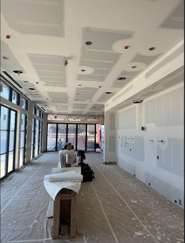 A large room that is being remodeled with a lot of windows