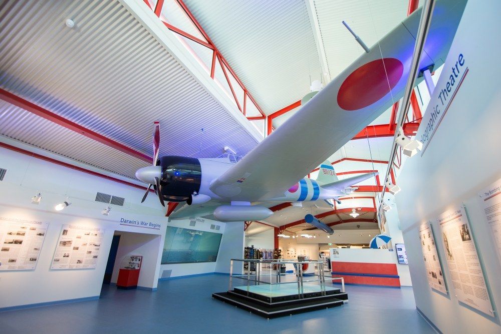 A plane is hanging from the ceiling inside the RFDS Tourist Facility. The words 'Things to Do' are written over the image.