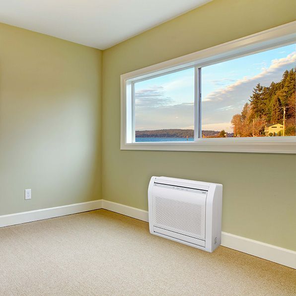 an empty room with a window and a fan on the floor .