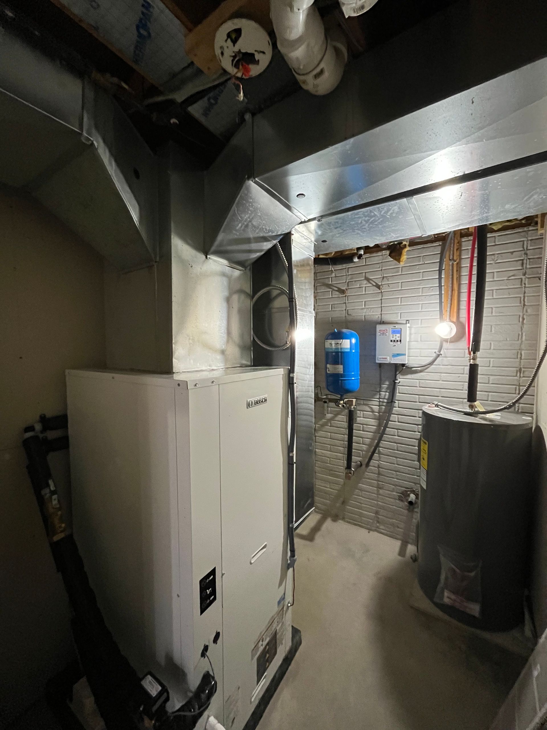 A room with a heater and a water heater in it.