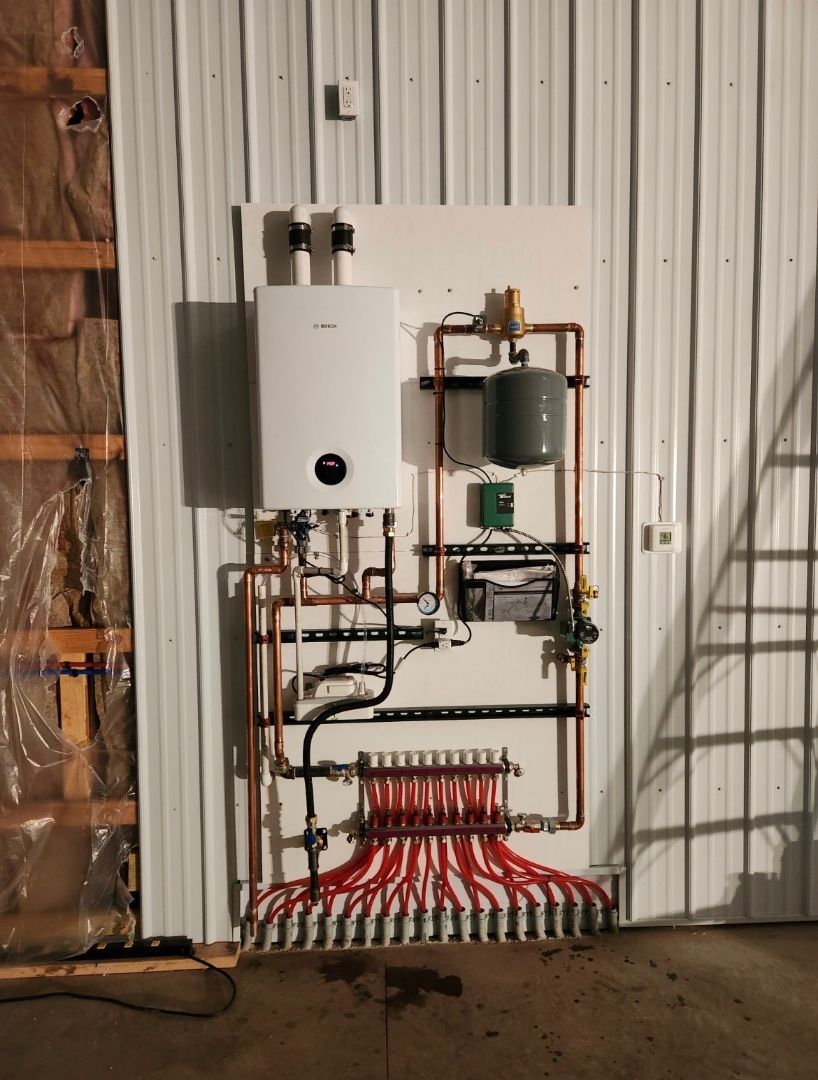 a wall with a boiler and a bunch of pipes on it