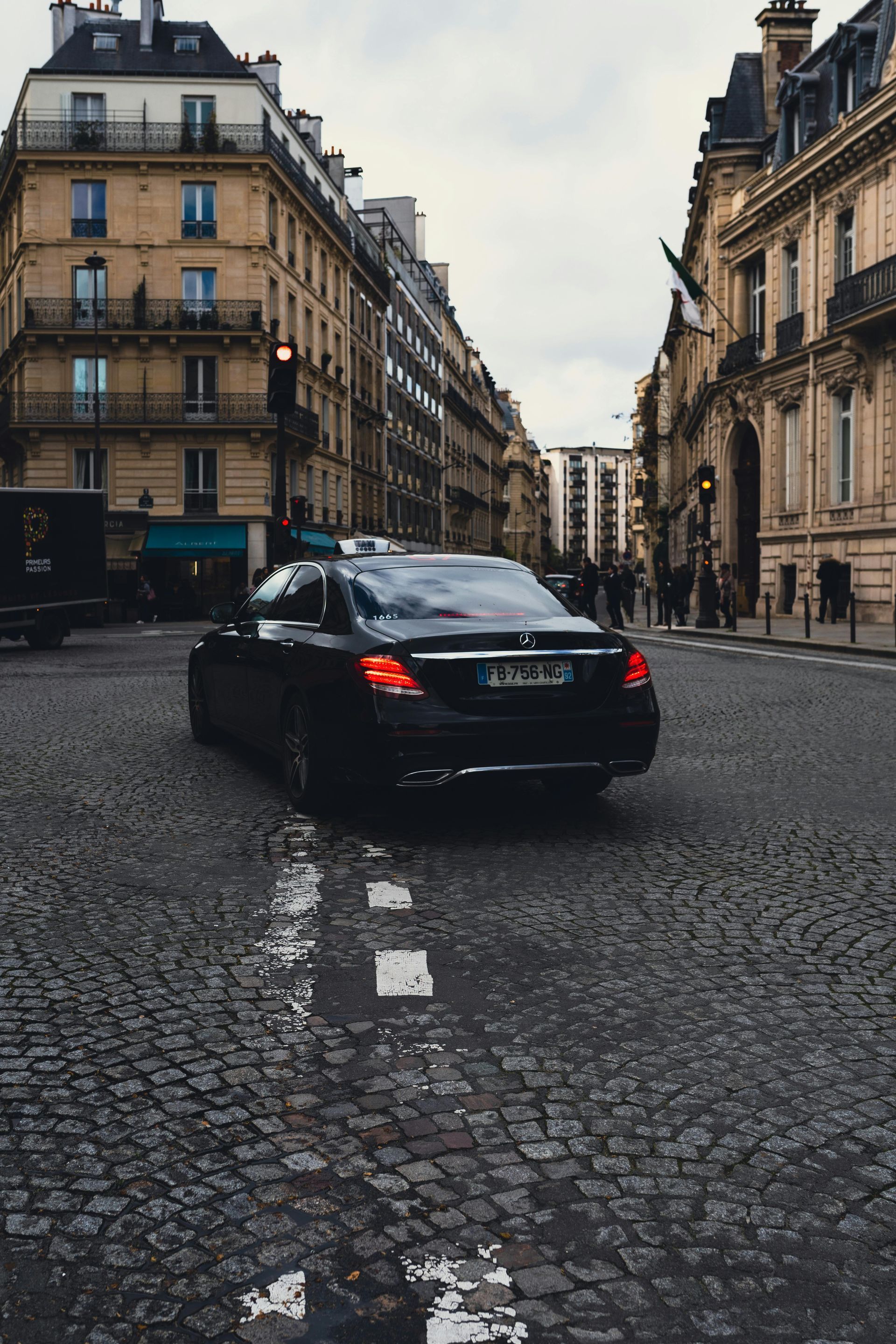 A black jeep is parked on the side of the road in front of a building.