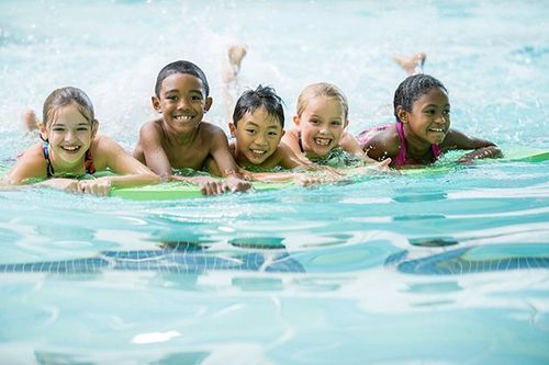 Kids swimming in a pool.