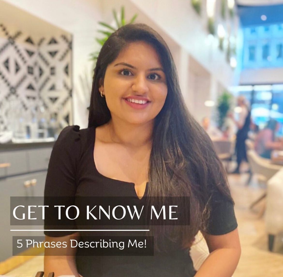 A woman is smiling in front of a sign that says get to know me