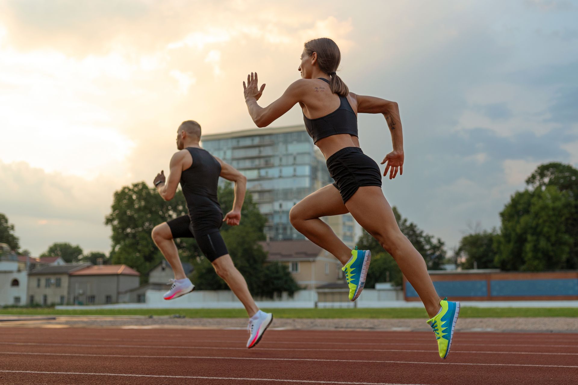 A man and a woman are running on a track.