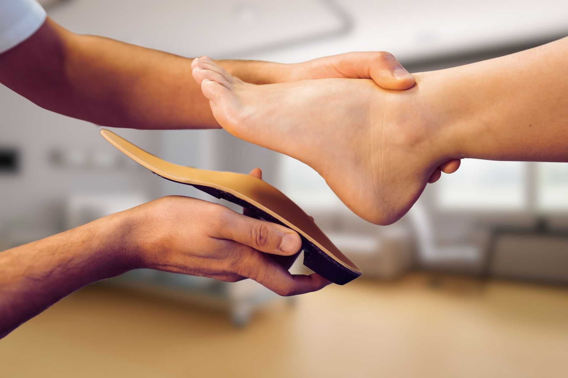 A person is putting a shoe insole on another person 's foot.