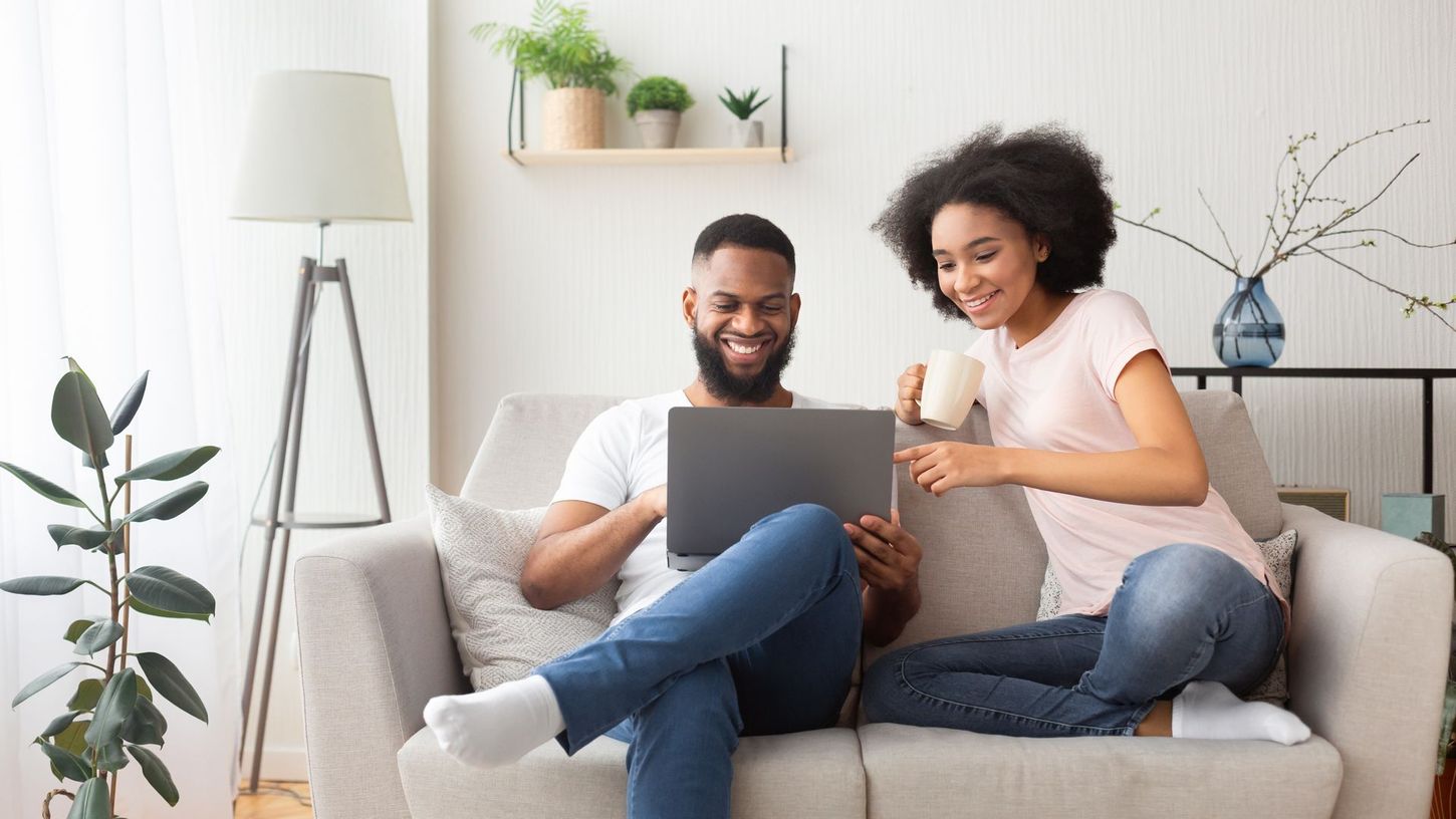 Couple on couch looking at laptop