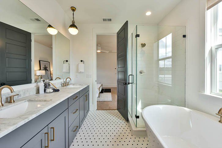 A bathroom with two sinks , a tub and a shower.