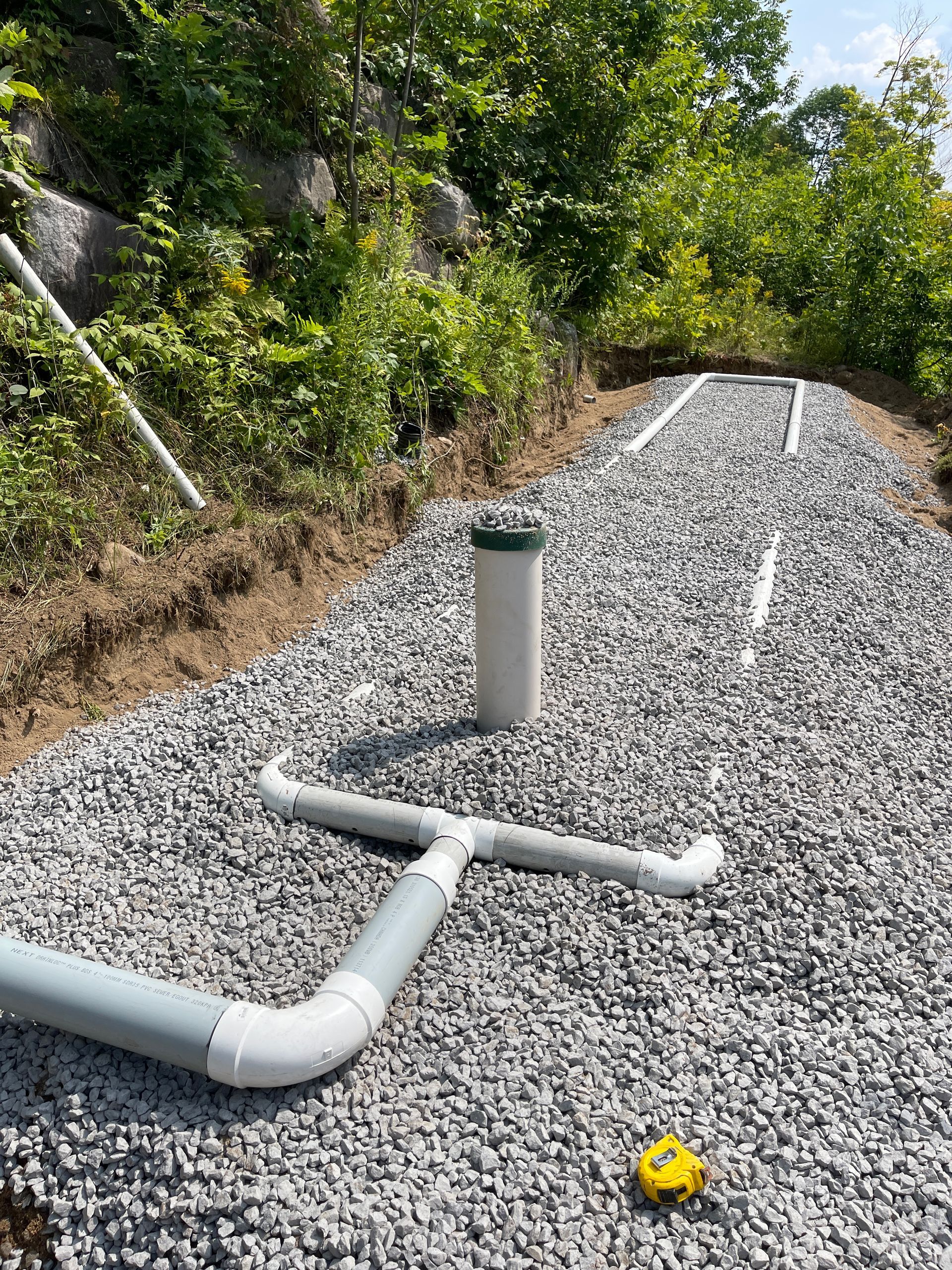 Un tuyau se trouve au sommet d’une route de gravier.