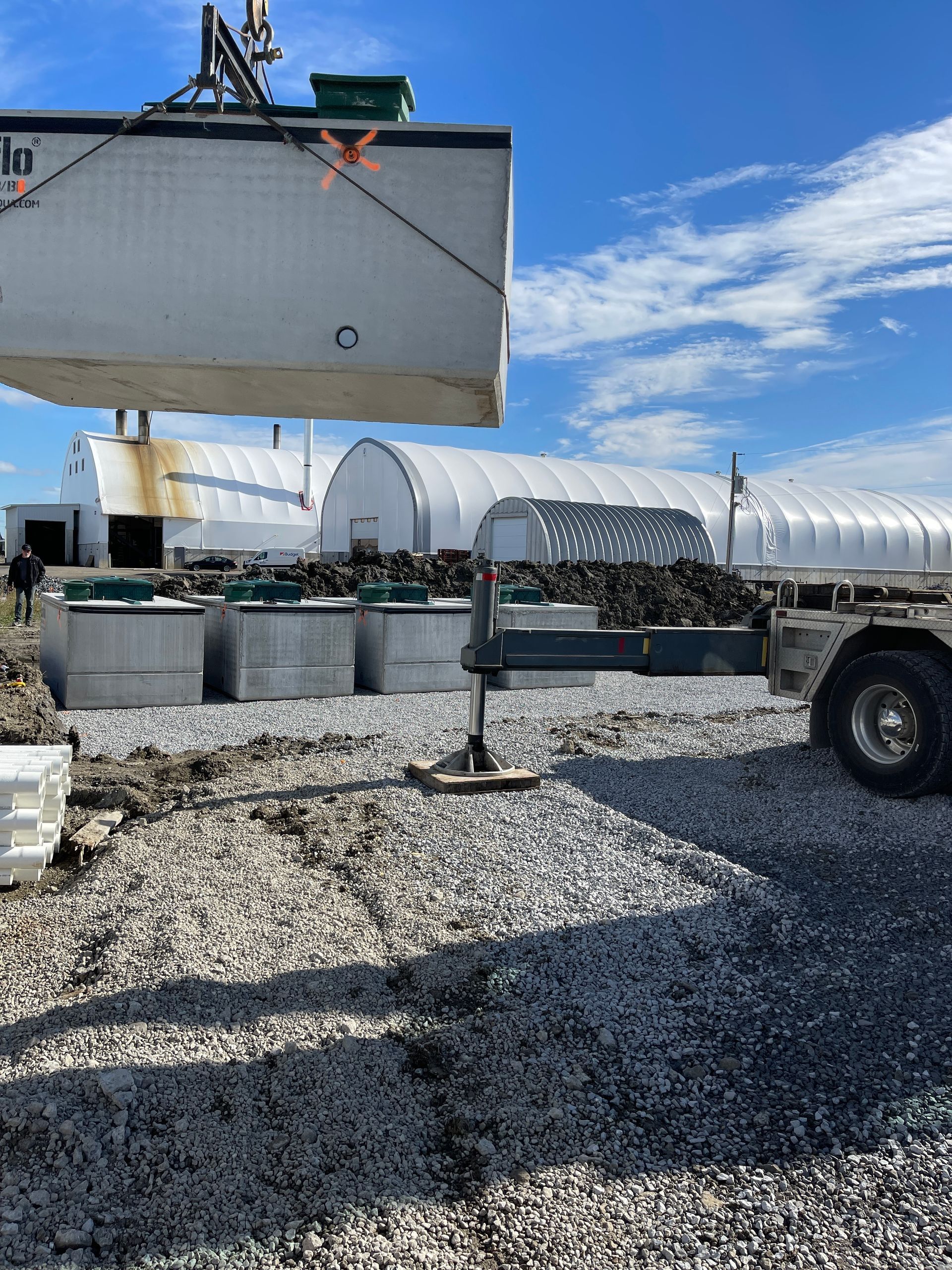 Un grand conteneur blanc est soulevé par une grue.