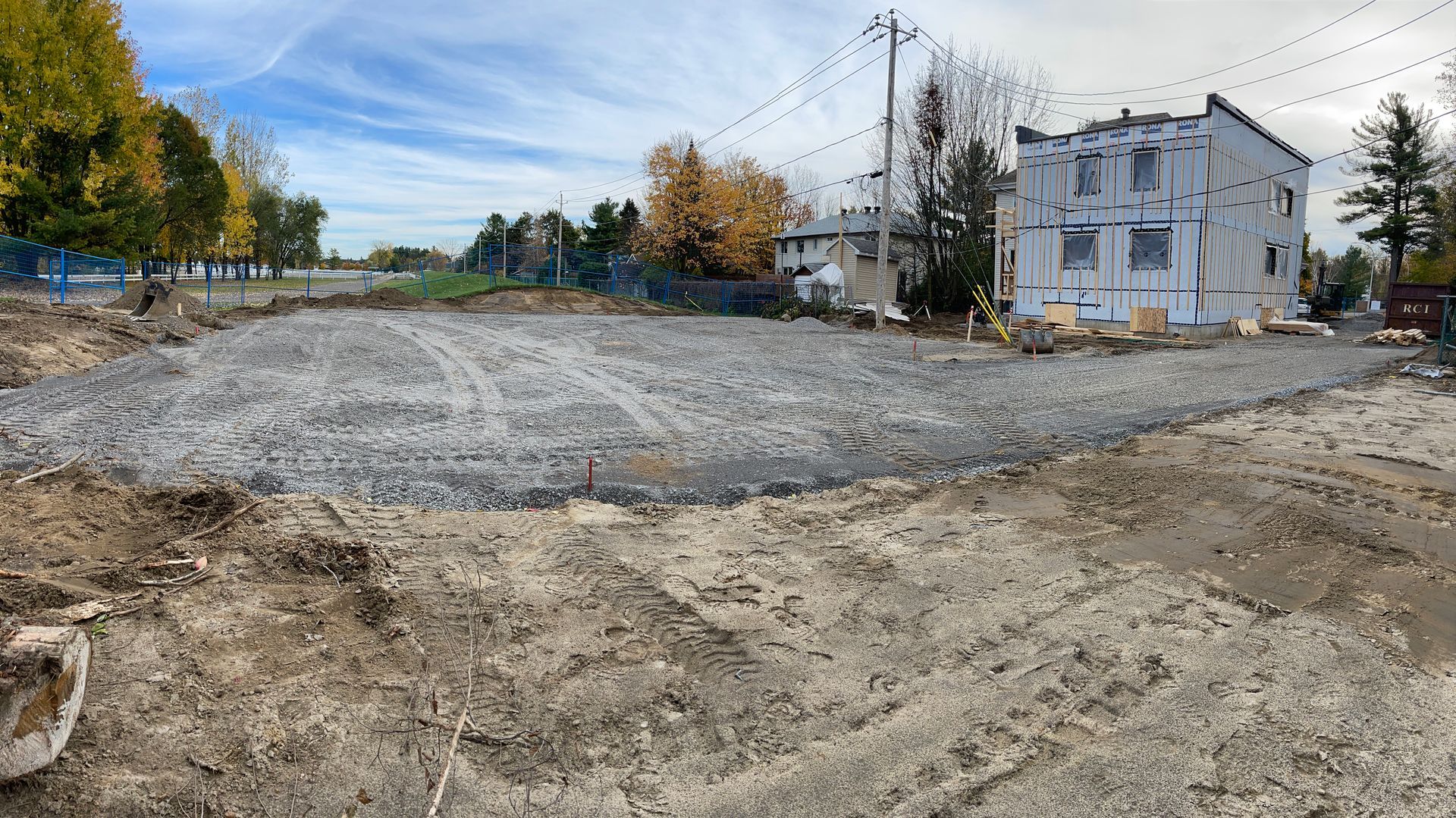Un grand champ de terre avec une maison en arrière-plan.