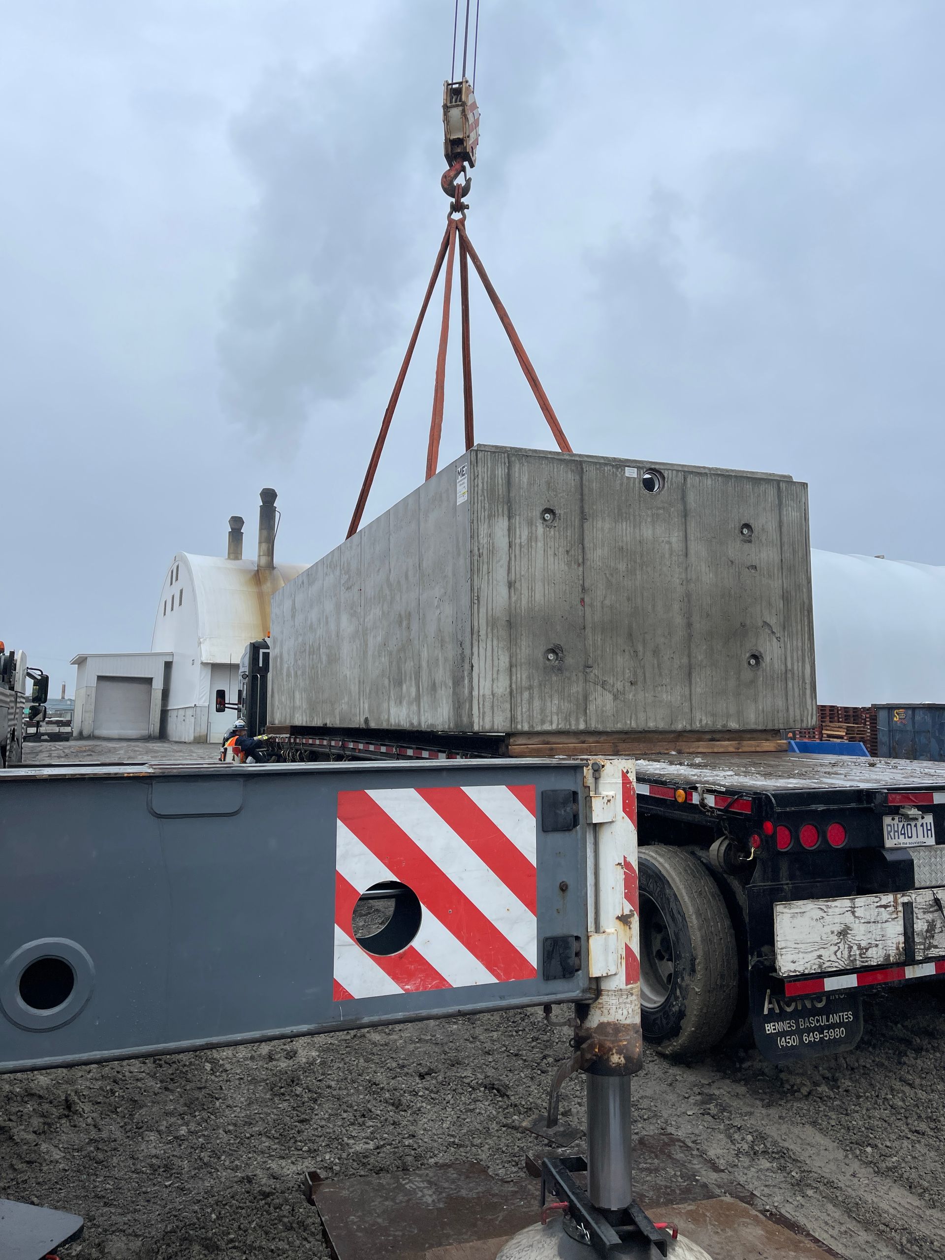Un gros bloc de béton est soulevé par une grue