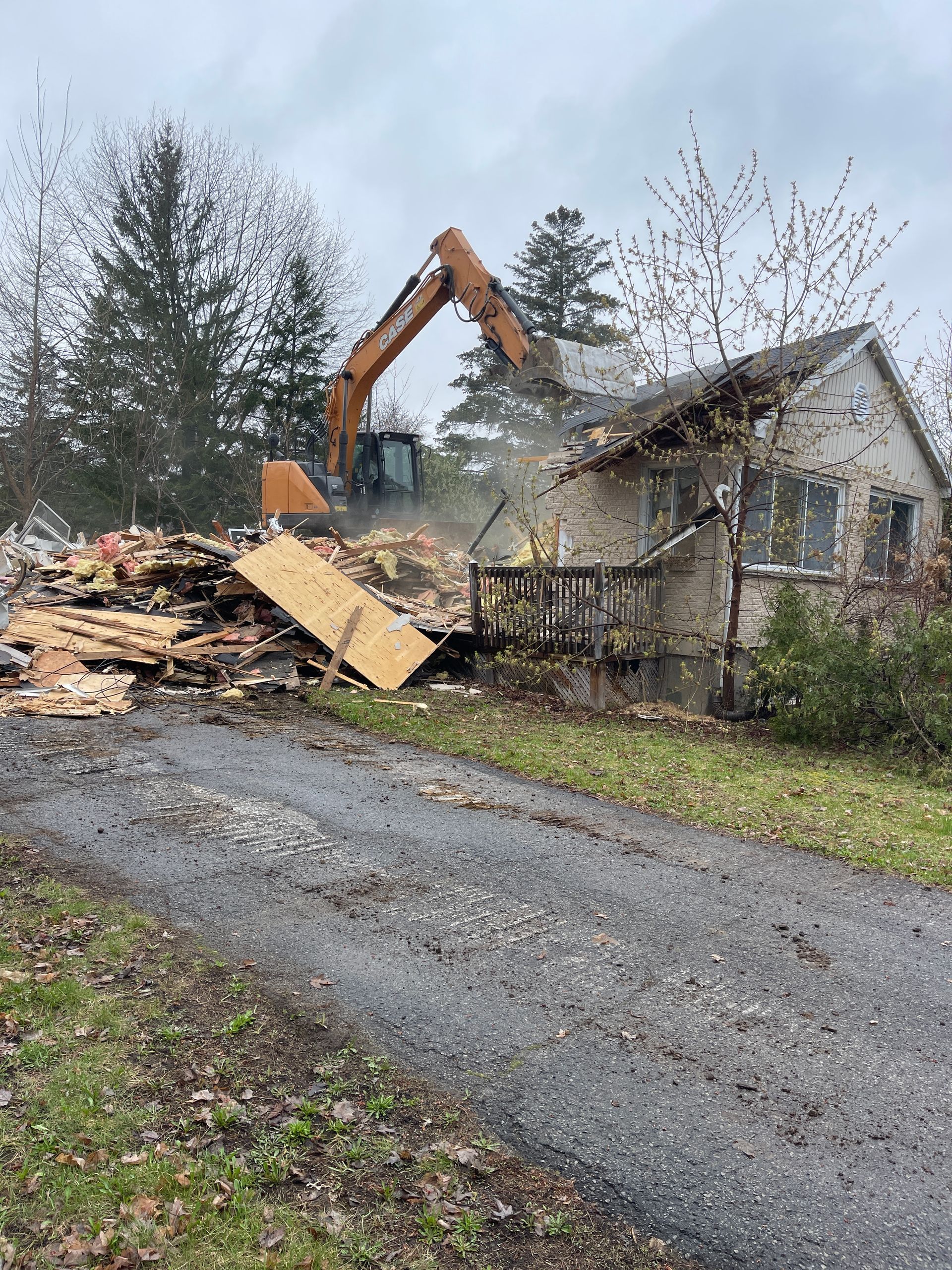 Une maison est démolie par une excavatrice.