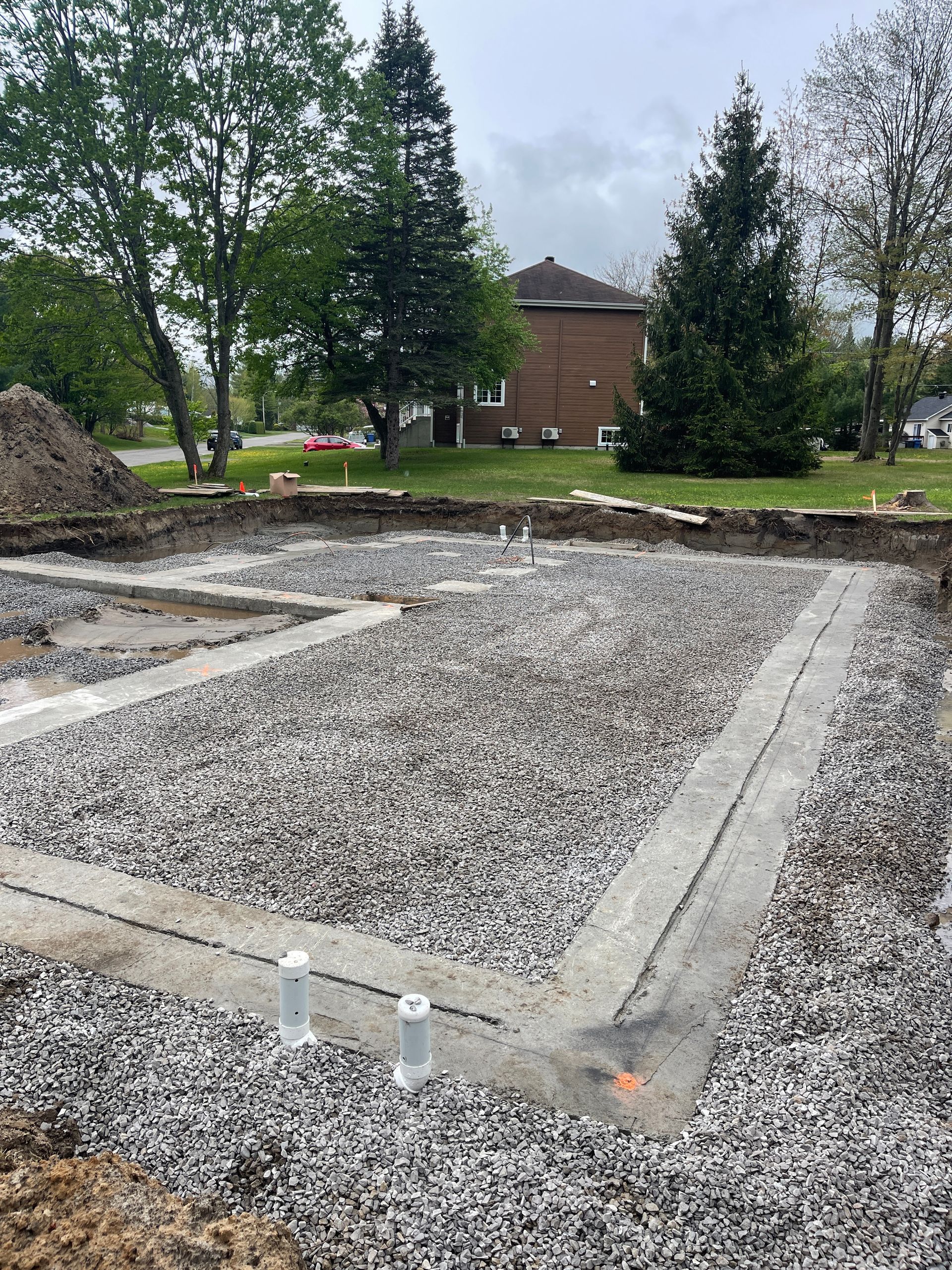 Un terrain en gravier avec un bâtiment en brique en arrière-plan.