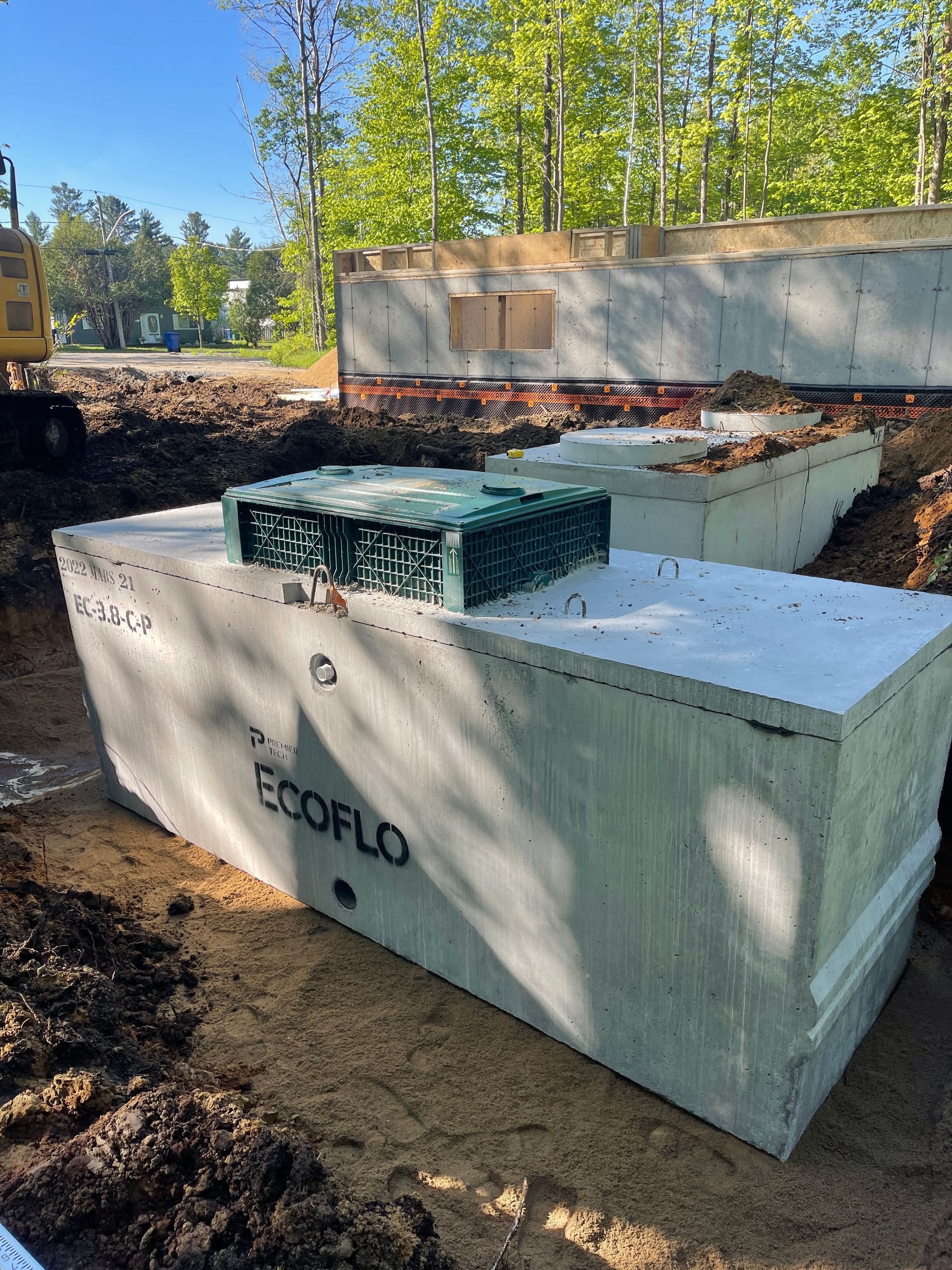 Une fosse septique en béton repose dans la terre sur un chantier de construction.
