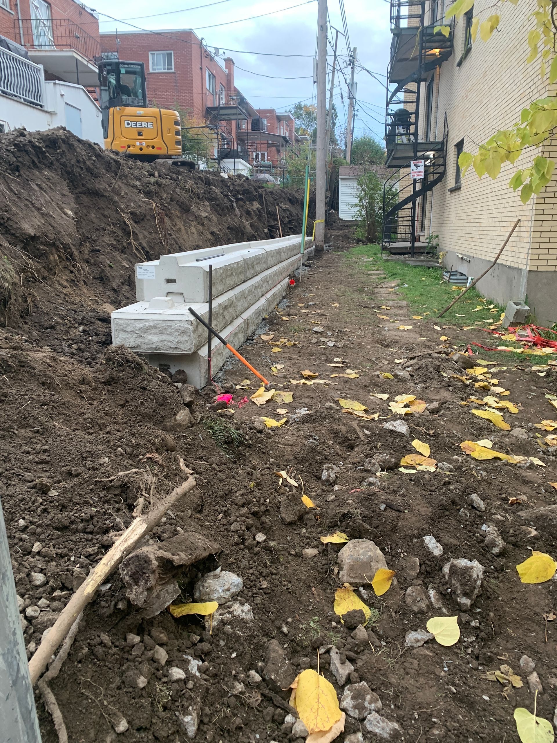 Un gros tas de terre et de roches est en train d’être construit à côté d’un bâtiment.