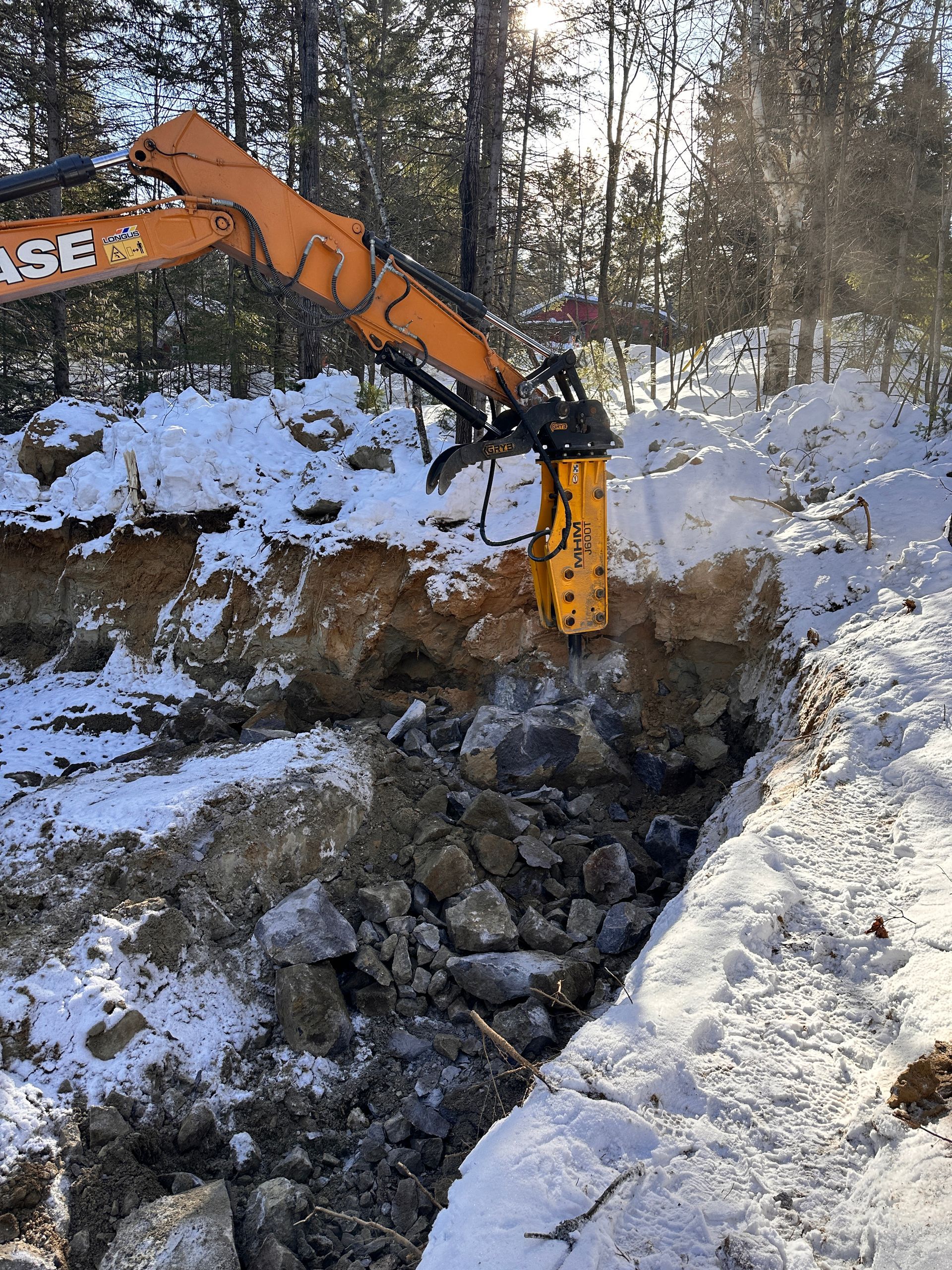 Une excavatrice creuse un trou dans la neige.