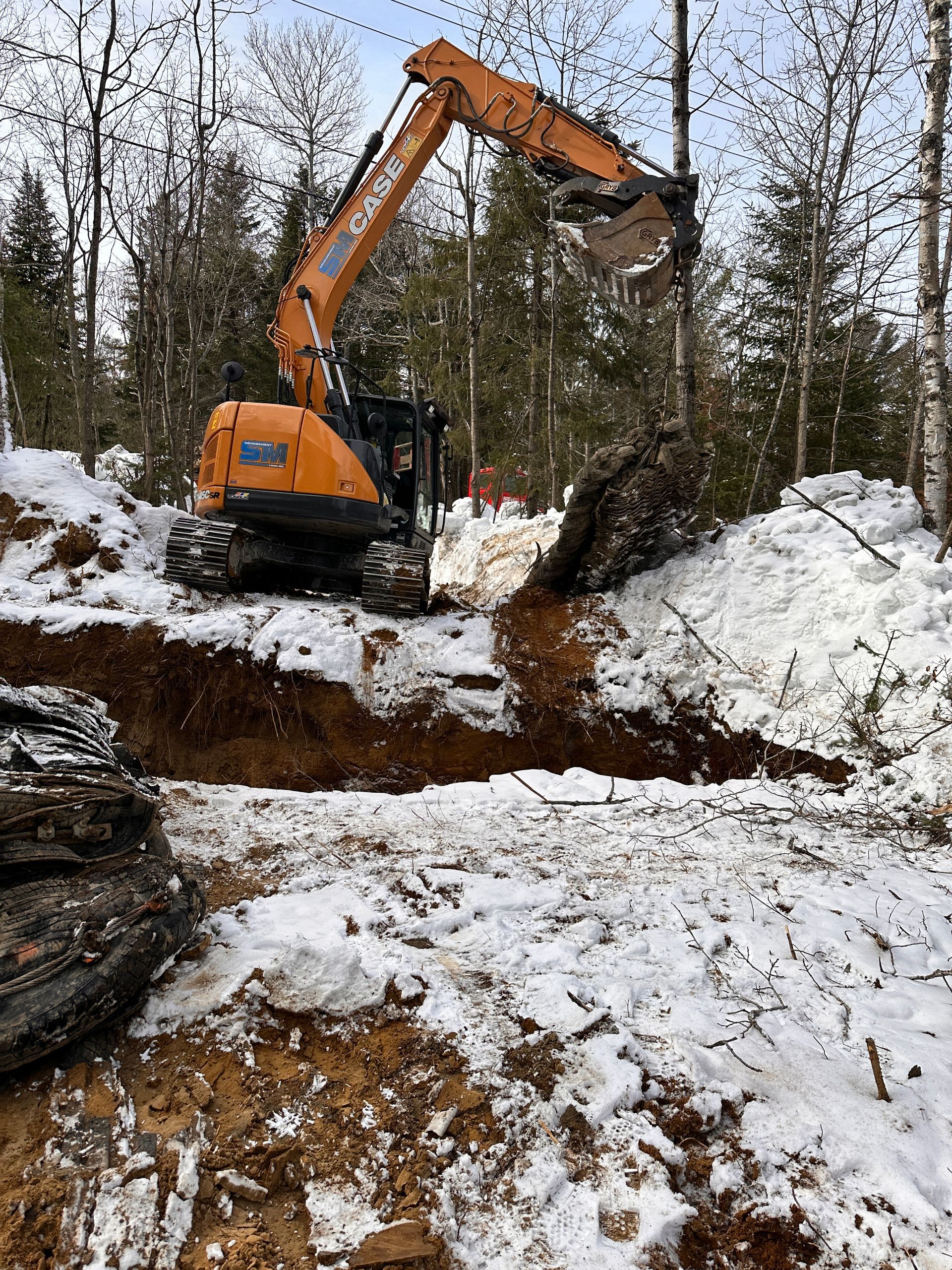 Une grosse pelle creuse un trou dans la neige.