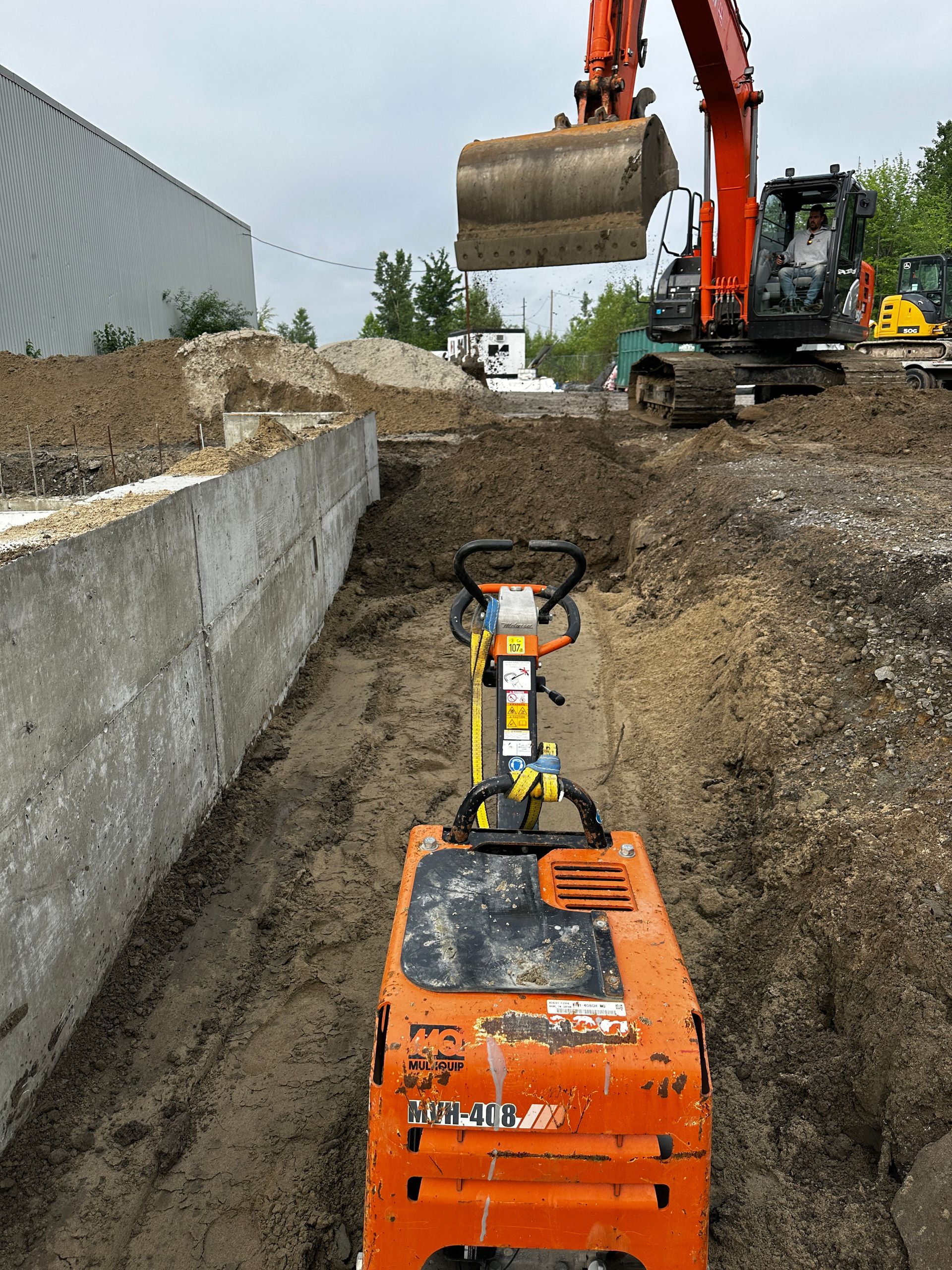 Un bulldozer creuse un trou dans la terre sur un chantier de construction.