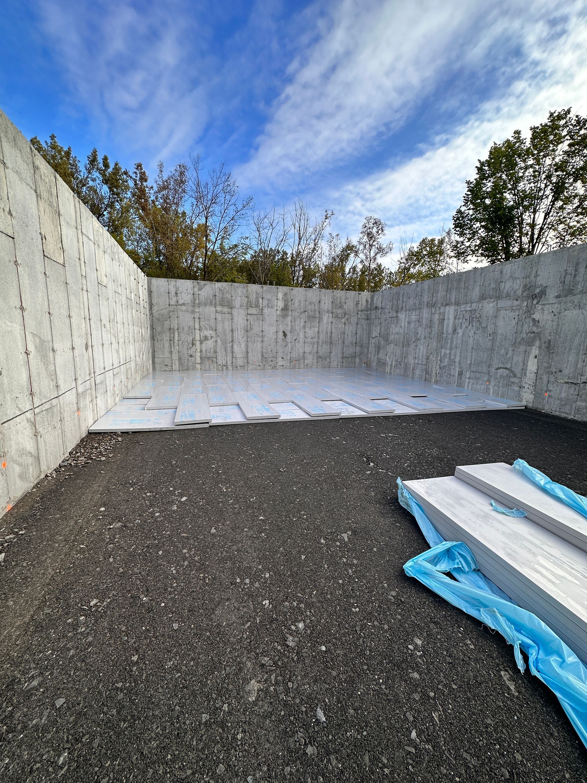 Un grand mur de béton repose sur un tas de gravier.