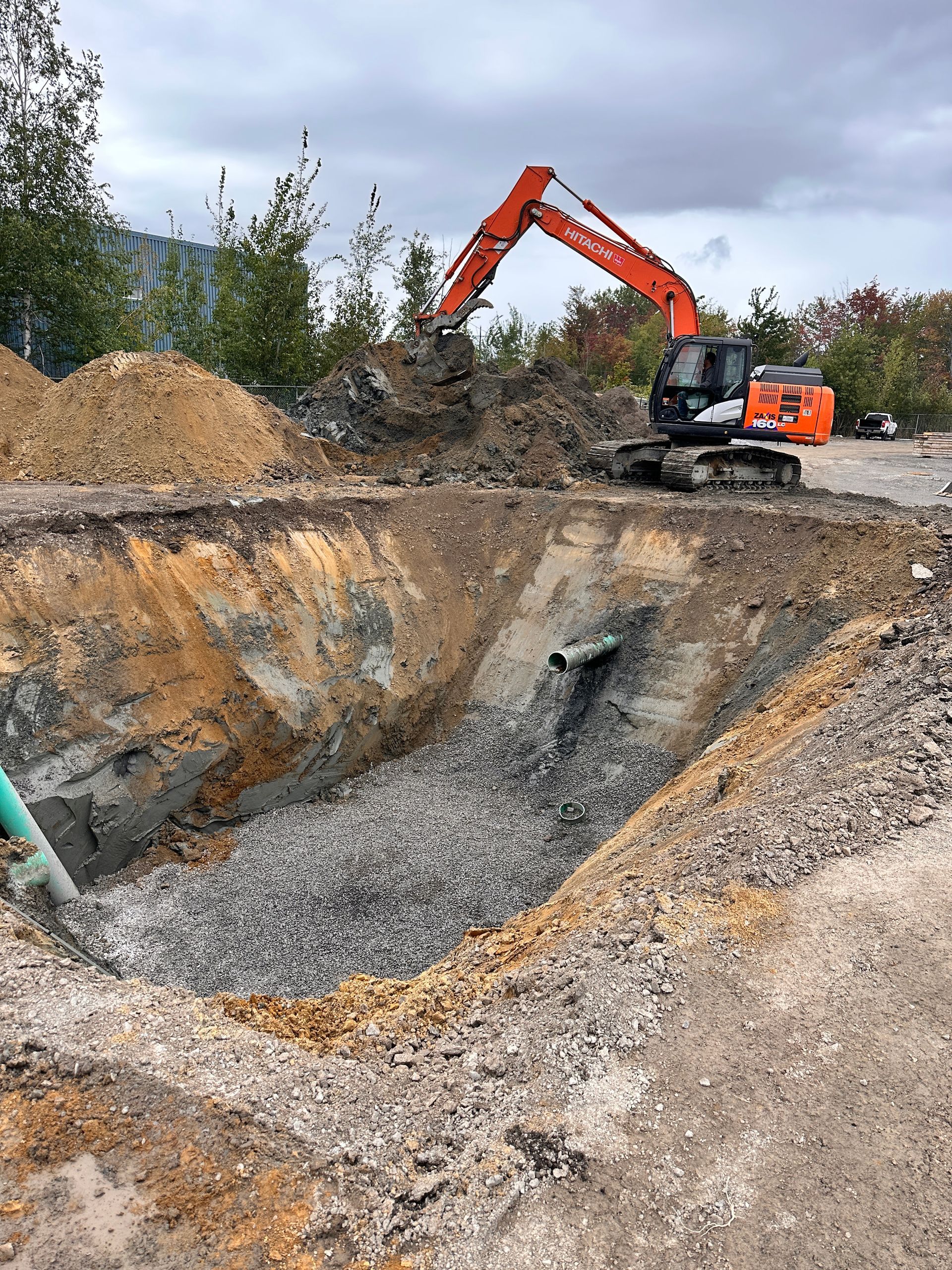 Une grosse excavatrice creuse un grand trou dans le sol.