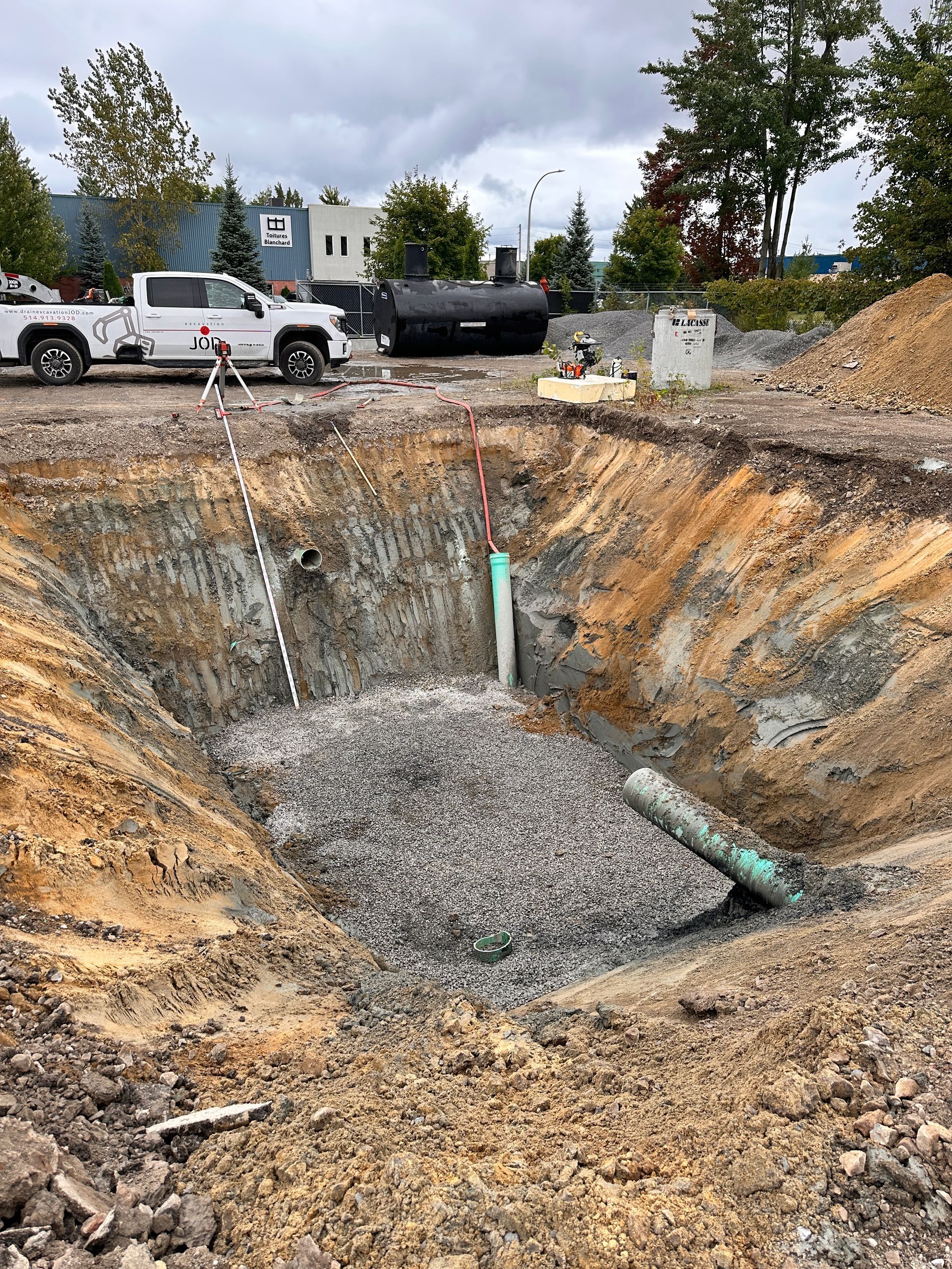 Un grand trou dans le sol avec un camion garé en arrière-plan.