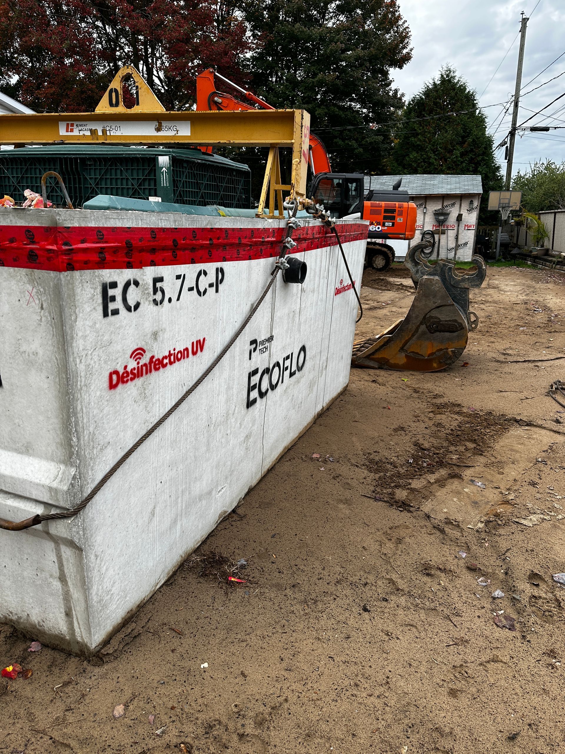 Un grand conteneur blanc se trouve au sommet d’un champ de terre.