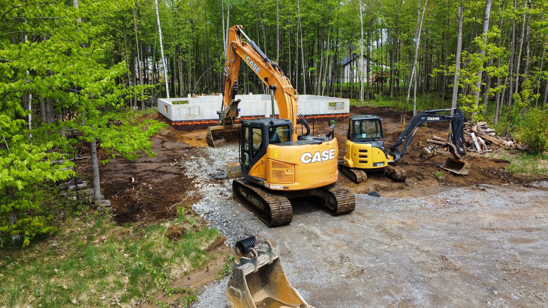 Quelques excavatrices travaillent sur un chantier de construction dans les bois.