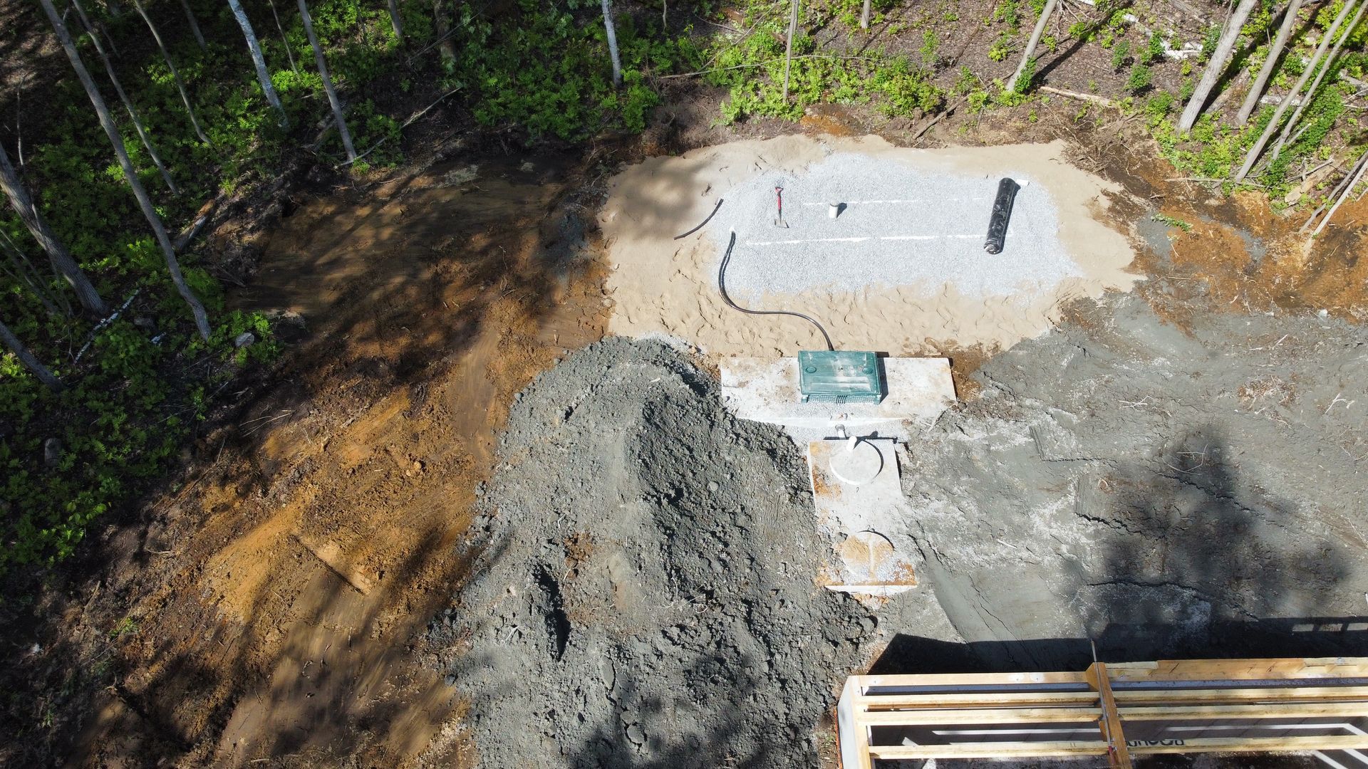 Une vue aérienne d'un chantier de construction au milieu d'une forêt.