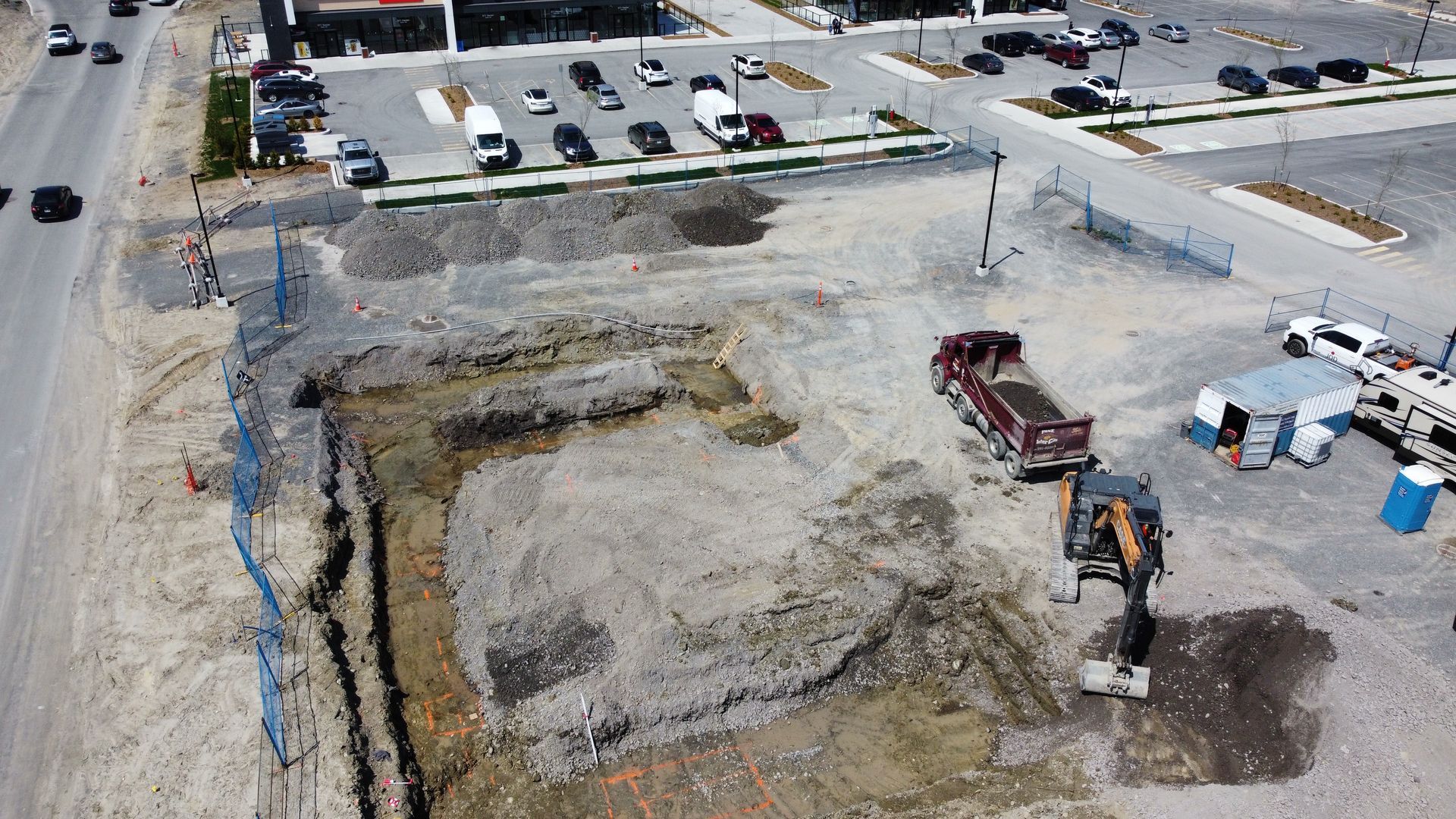 Une vue aérienne d’un chantier de construction avec un camion-benne au milieu.