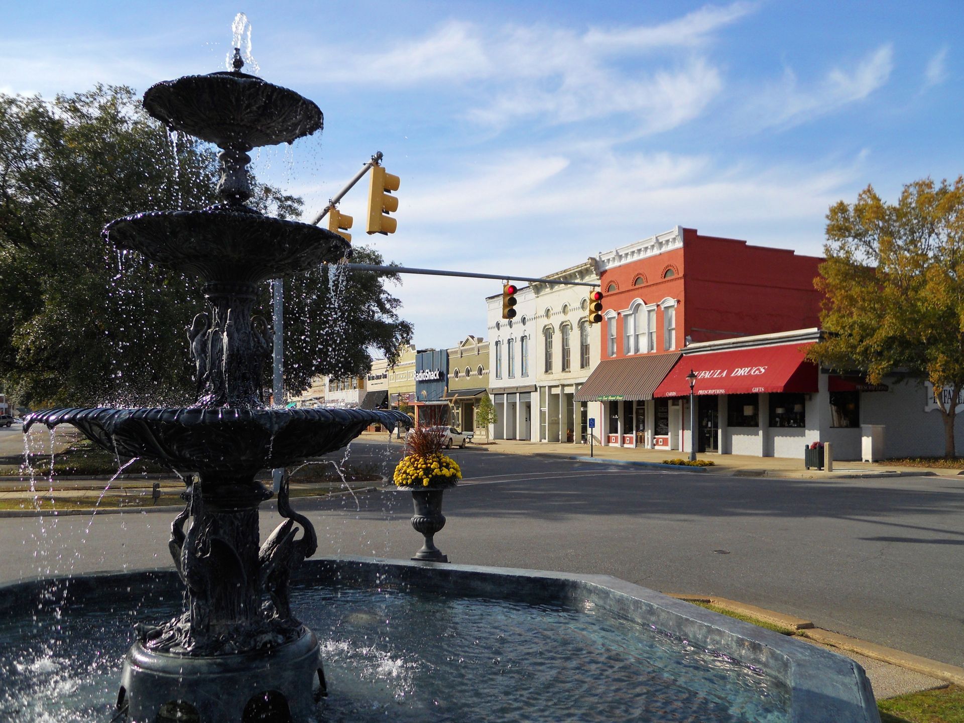 A fountain in the middle of a street in a small town