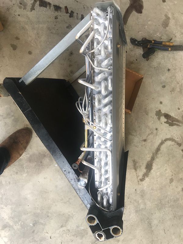 A close up of an air conditioner coil on the ground.