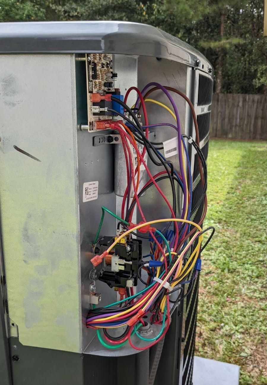 The inside of an air conditioner with a lot of wires coming out of it.