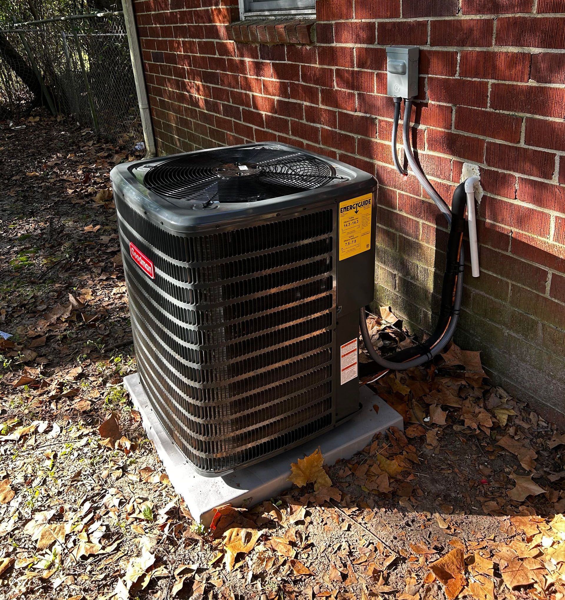 An air conditioner is sitting outside of a brick building