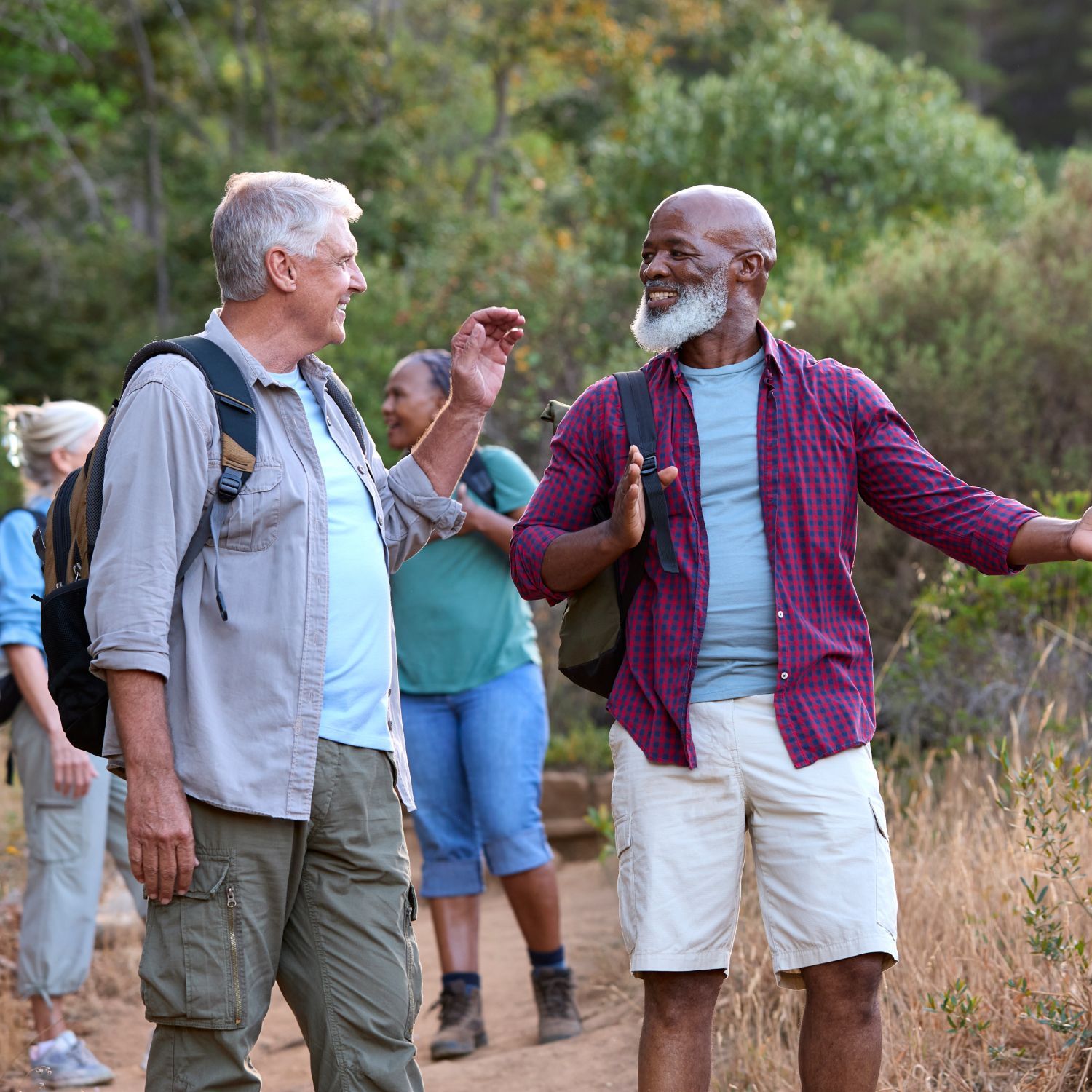 Two men are walking down a dirt path and talking to each other.