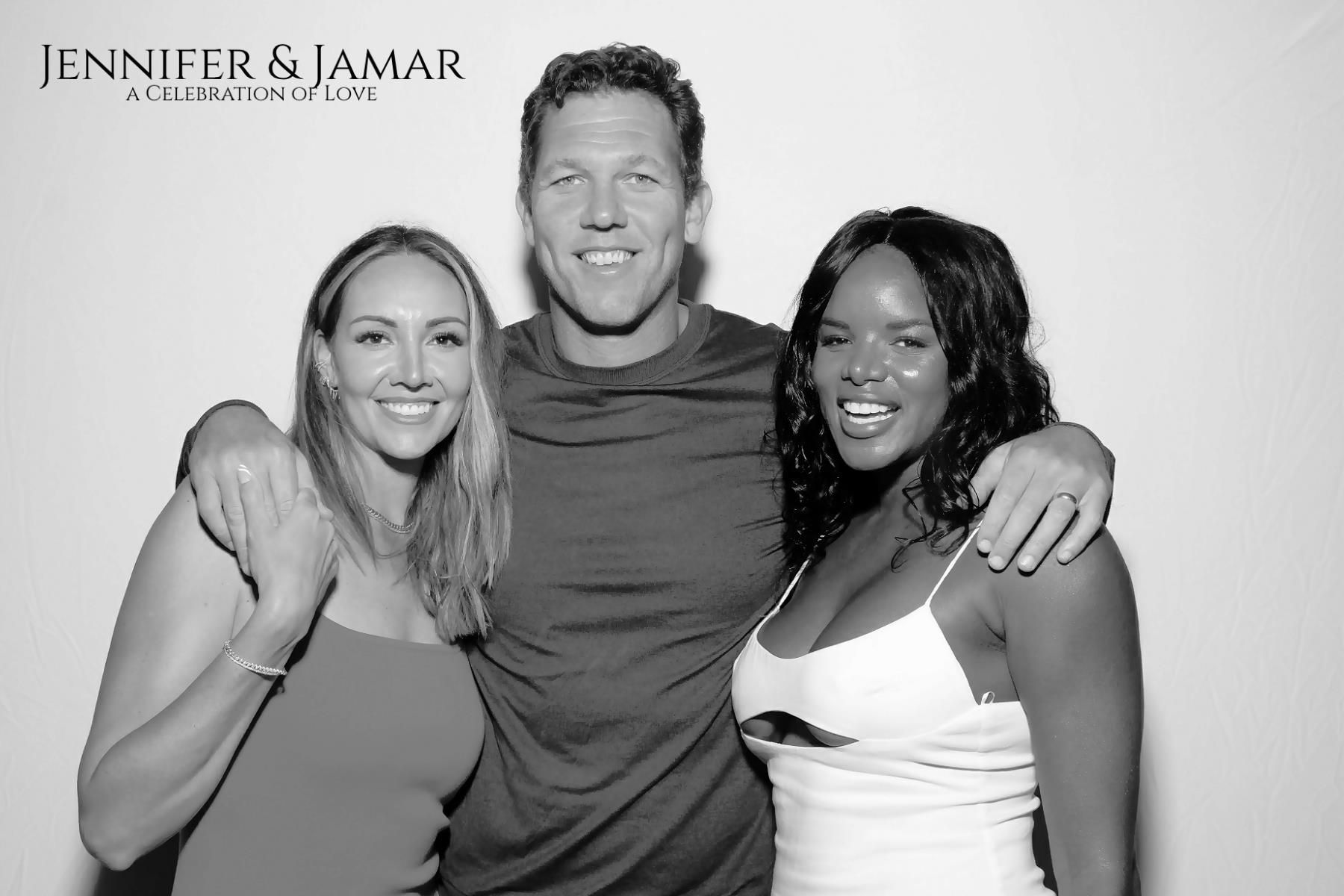 A black and white photo of a man and two women at our photo booth.