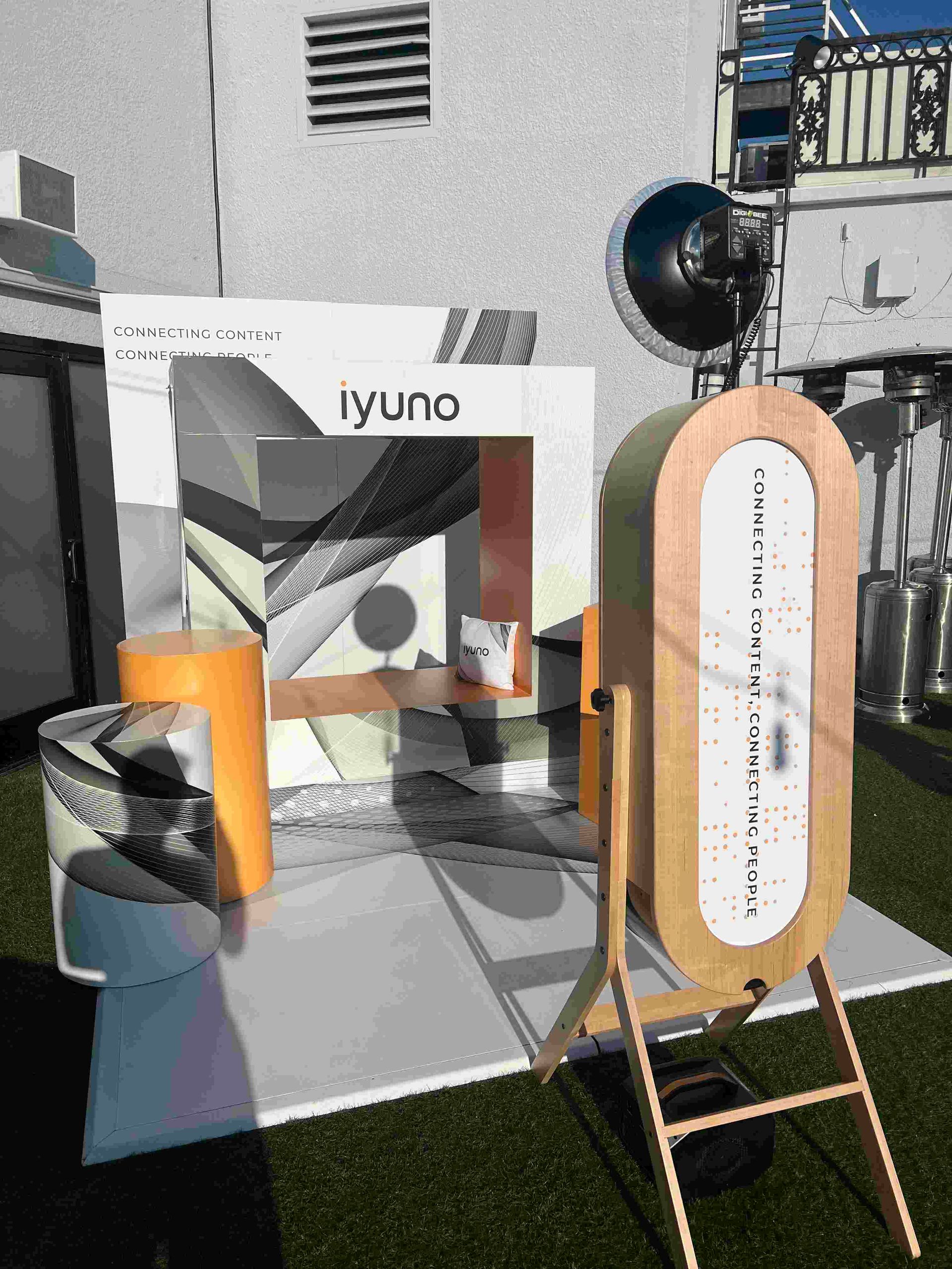 A photo booth is sitting on the grass in front of a building.