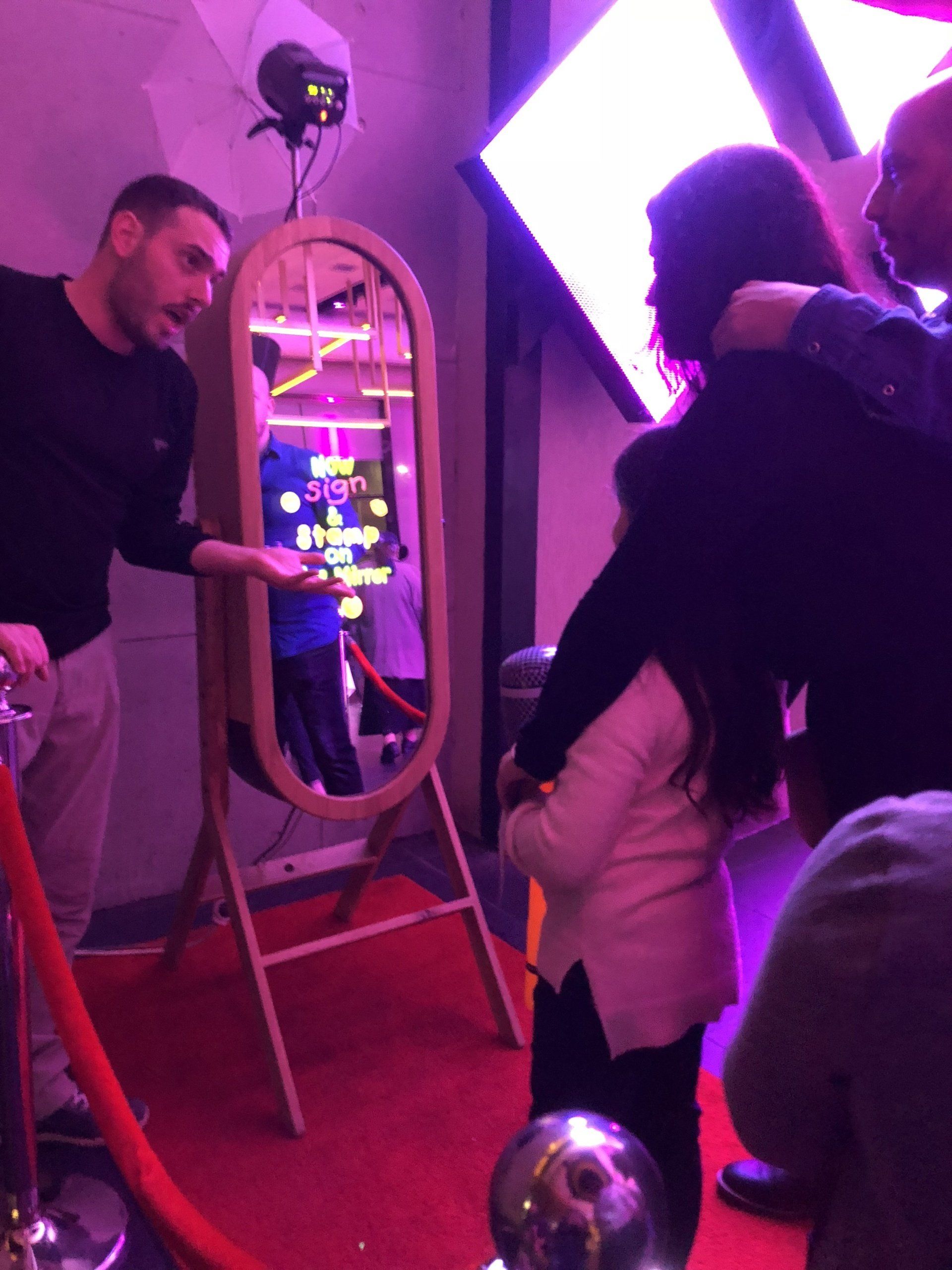 A group of people are posing for a picture in front of a mirror
