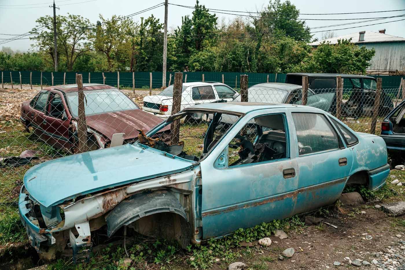 A bunch of old cars are sitting in a field.