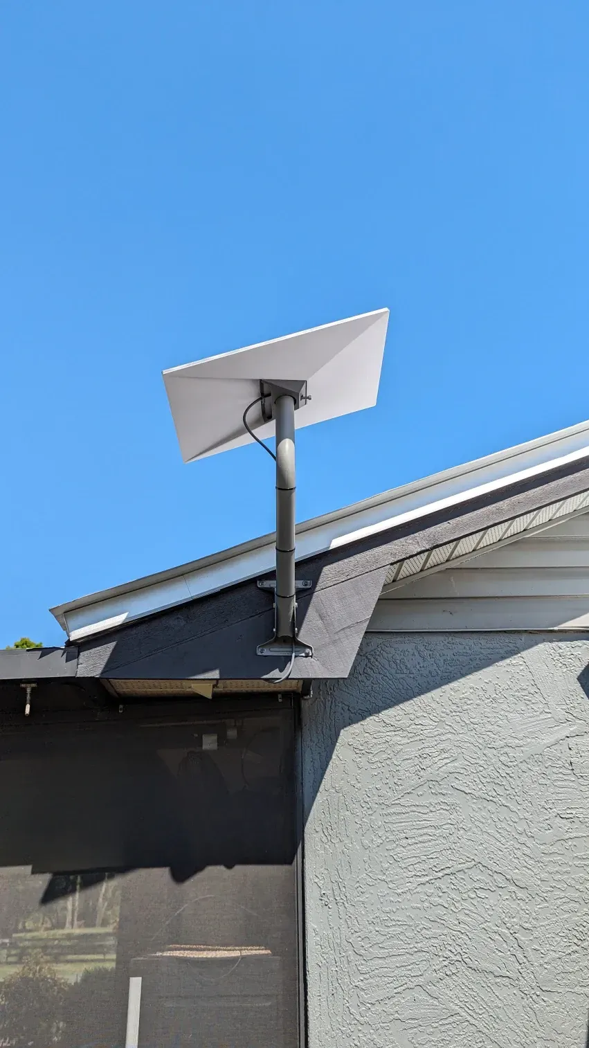 A satellite dish is mounted on the roof of a building.