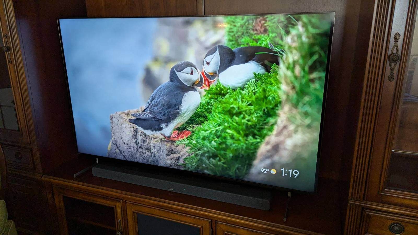A flat screen tv is sitting on top of a wooden entertainment center.