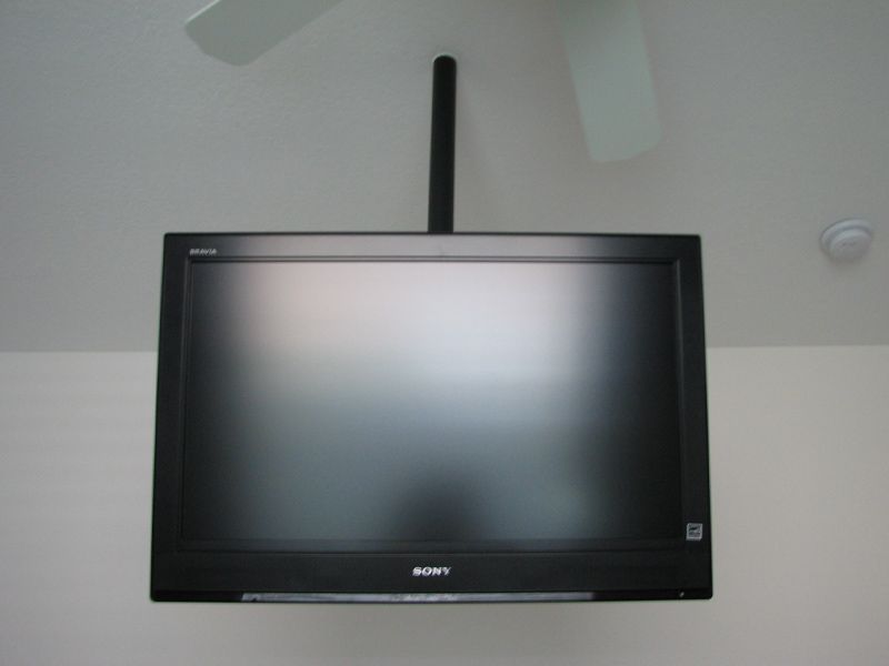 A sony television is hanging from the ceiling