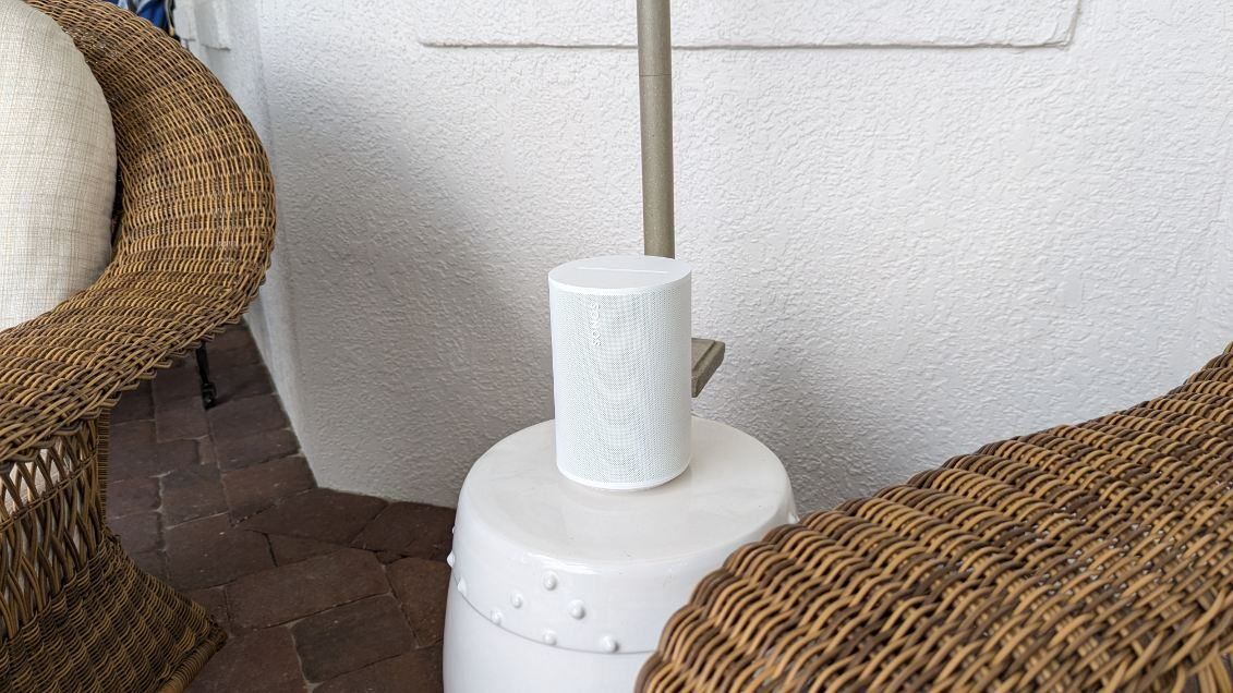 A wicker chair and a lamp are sitting next to each other on a patio.